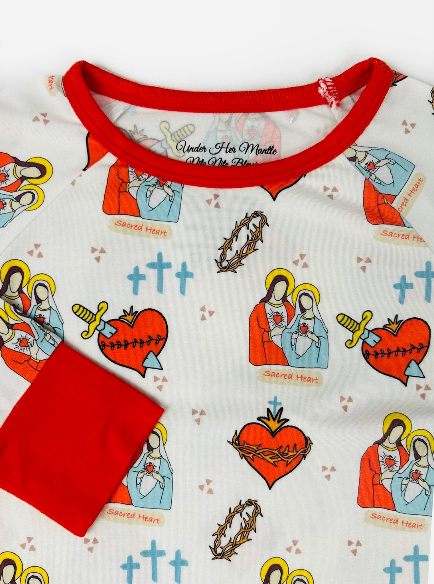 Children's pajama set with a pattern of the Sacred Heart of Jesus and Immaculate Heart of Mary and an embroidered rosary wrist detail